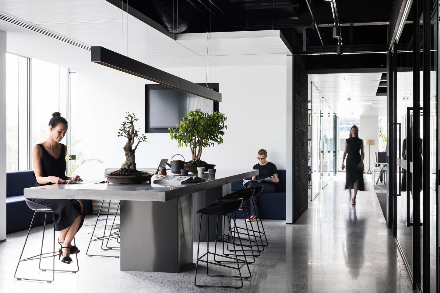Modern office space with people working at a communal custom concrete desk.