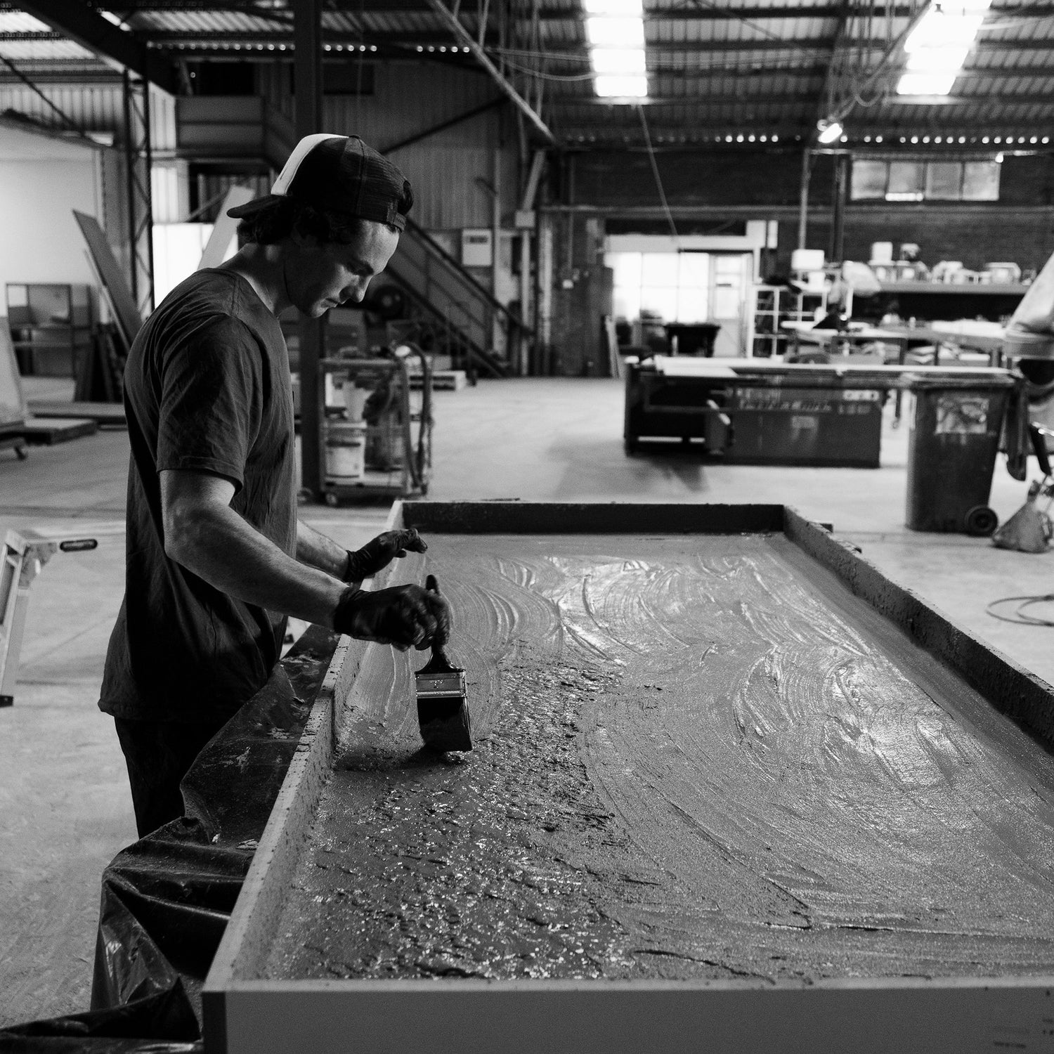 Concrete technician working on a concrete vanity in the workshop.