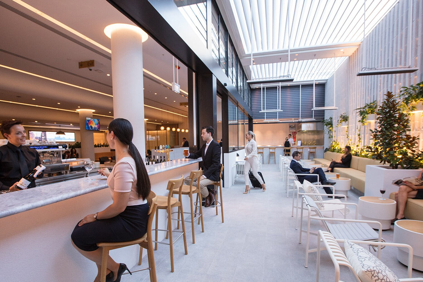 Modern interior of a cafe in a business class lounge, with modern concrete tables ,people sitting and walking around.