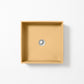 Square concrete basin in Ochre, a muted golden yellow with warm earthy tones, shown from above against a white background.