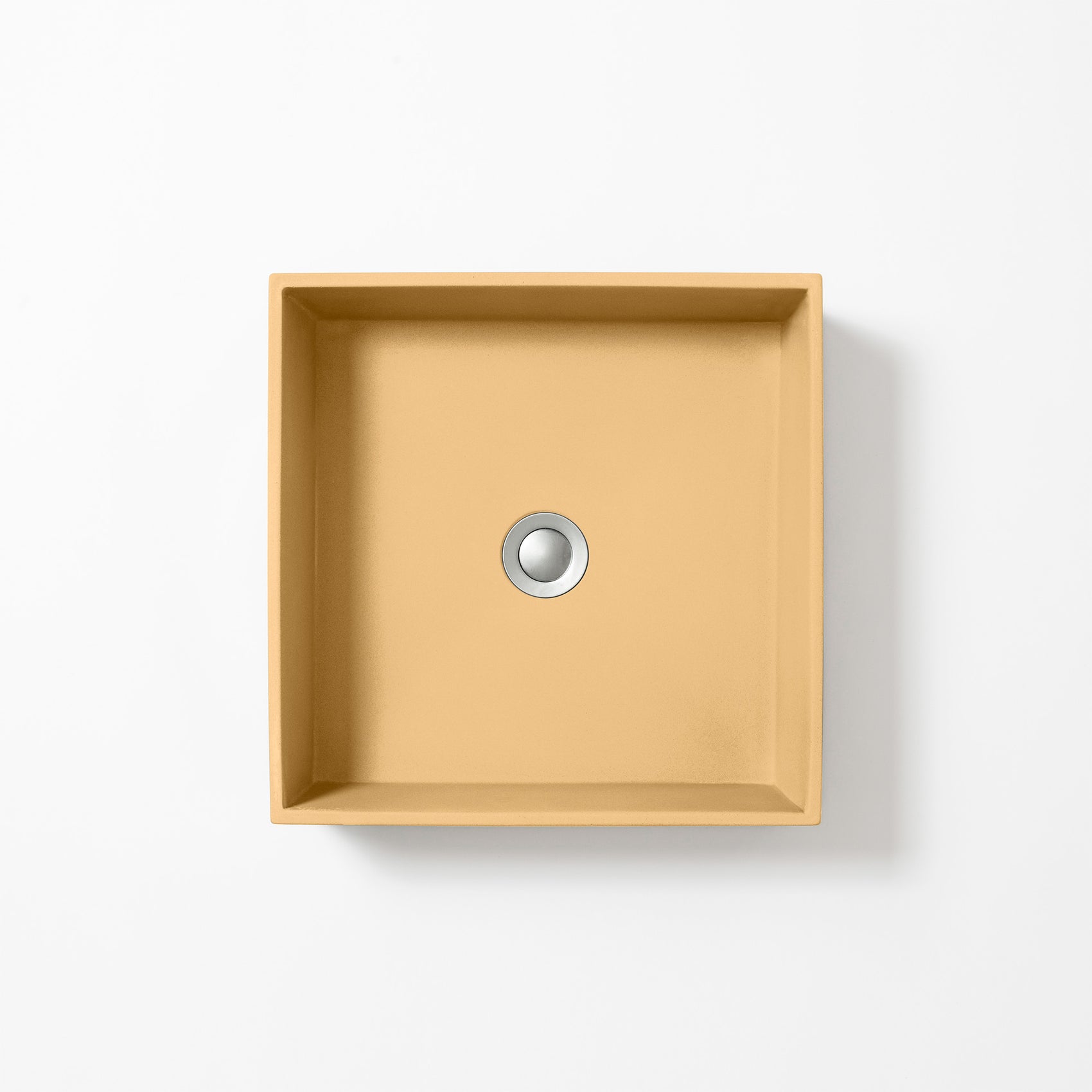 Square concrete basin in Ochre, a muted golden yellow with warm earthy tones, shown from above against a white background.