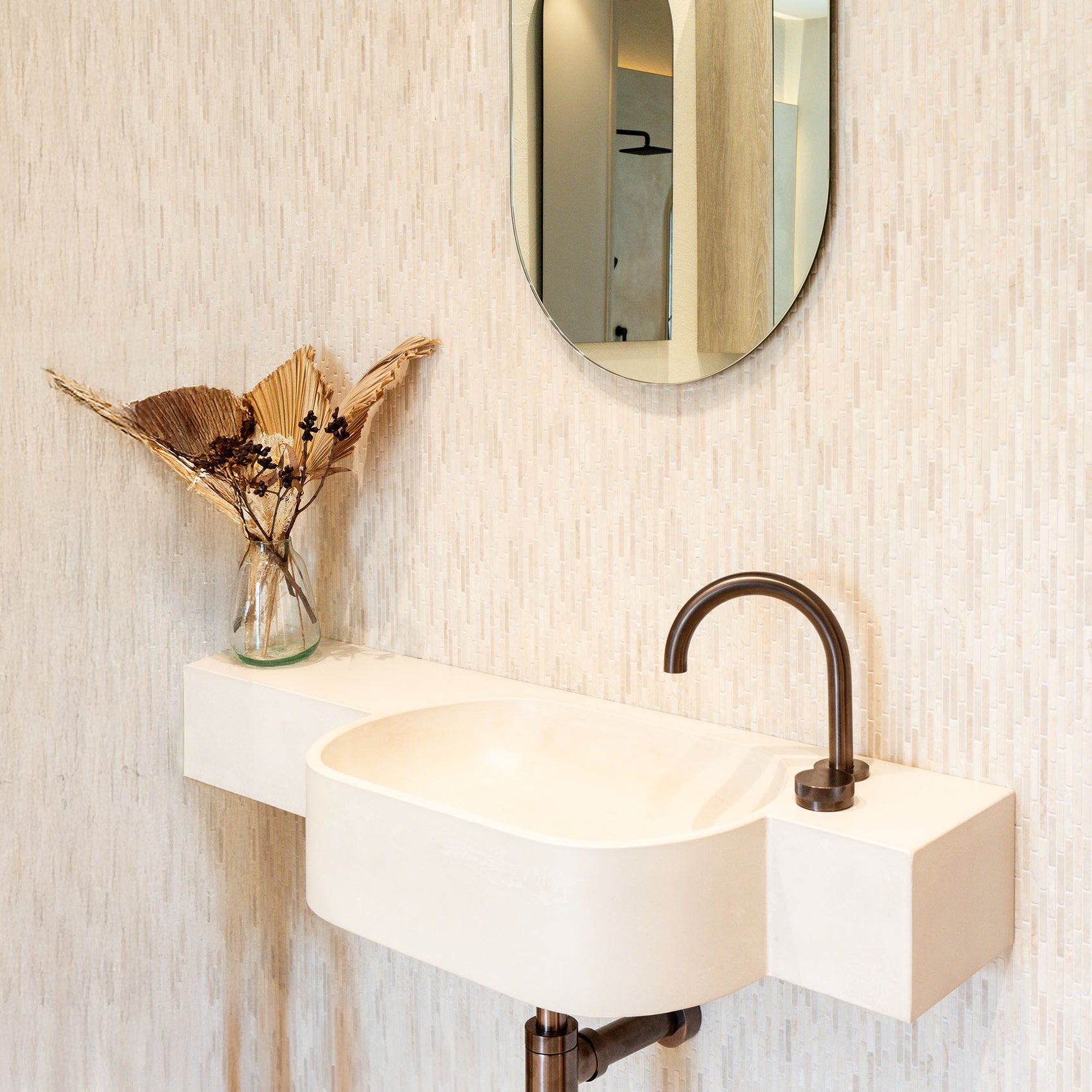 Kaarla - Semi-recessed Concrete Vanity in a modern bathroom the sink features a slim space-saving profile with an integrated oval husk-coloured basin.