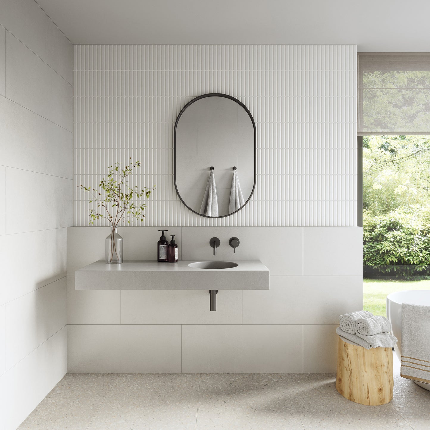 Wirli single concrete vanity, wall-mounted without brackets. Featuring a integrated cylindrical basin, hand-cast in GFRC concrete for a smooth, matte finish. Here pictured in a minimal modern bathroom with white narrow tiles and brushed gunmetal steel mixer taps.